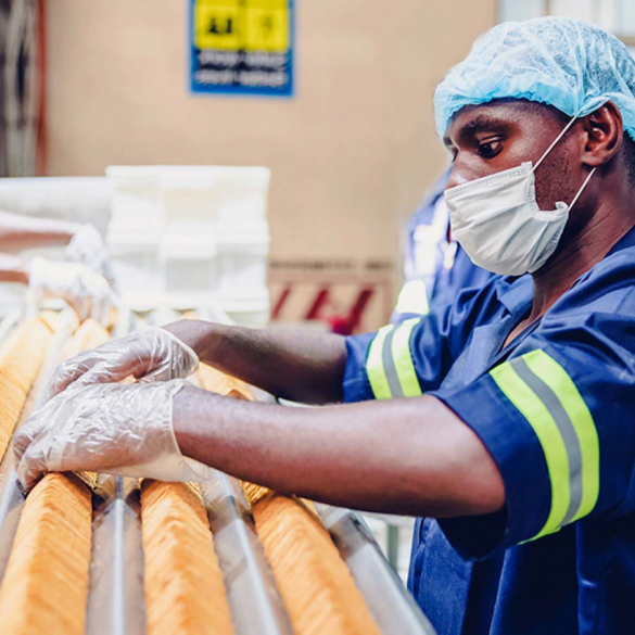 Man working on Food Production Line wearing hair net and mask